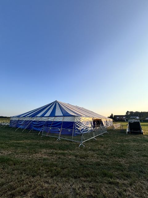 De grote tent op de wei bij zonsondergang